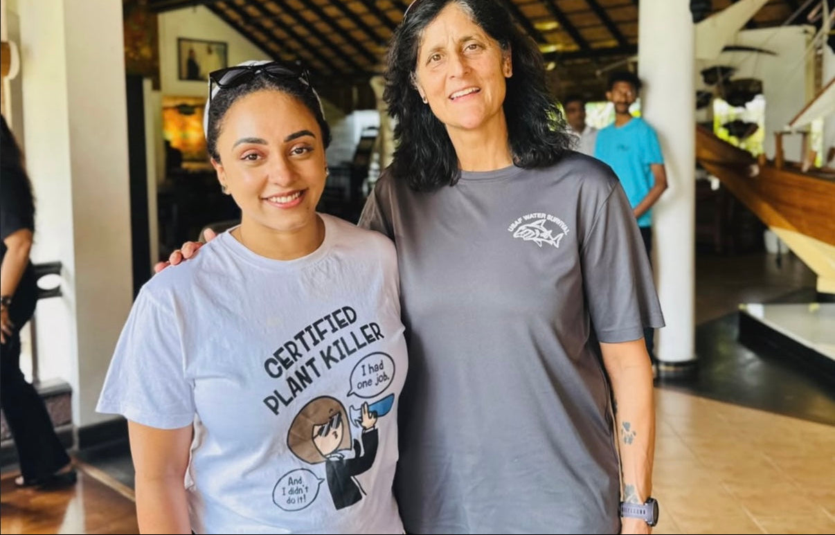 Two women standing together in a casual setting, one wearing a 'Certified Plant Killer' t-shirt.