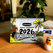 Comic calendar for 2026 on a table with a plant in the background