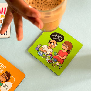 Hand holding a glass of iced coffee above a coaster with cartoon characters on a light surface.