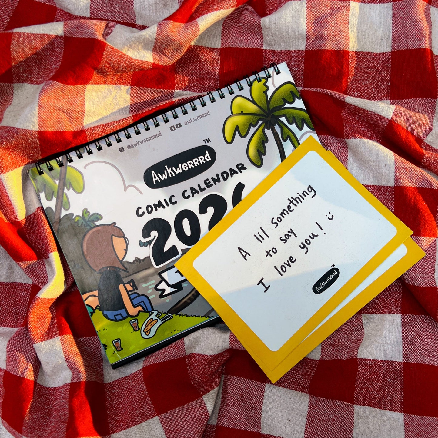 Notebook and card on a red and white checkered fabric