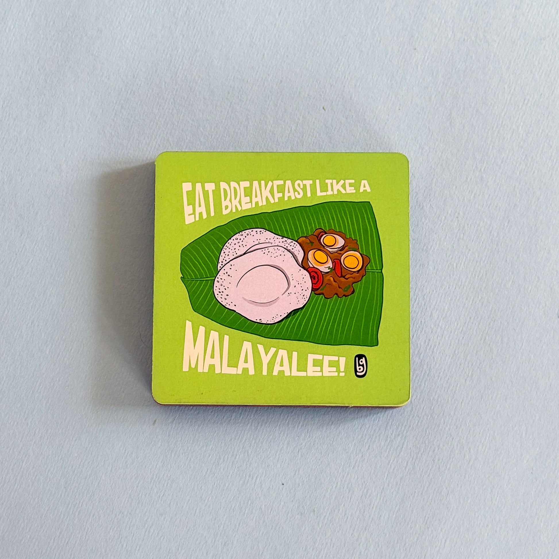 Square magnet with food illustration and text on a light gray background