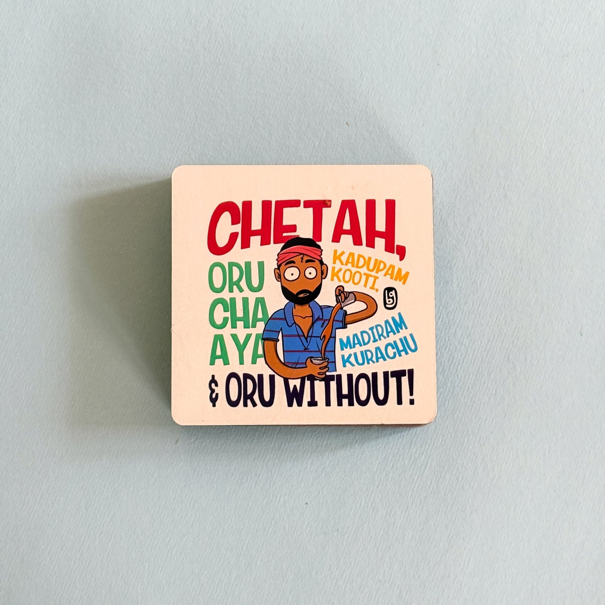 Square wooden coaster with colorful design and text on a light gray background