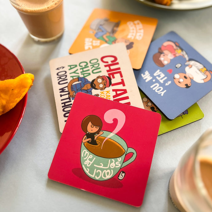 Colorful coasters with illustrations on a table with coffee and pastries