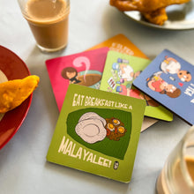 Colorful coasters with illustrations and text on a table with food and drinks.