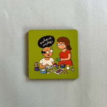 Cartoon magnet on a white surface with two people and text.