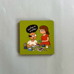 Cartoon magnet on a white surface with two people and text.